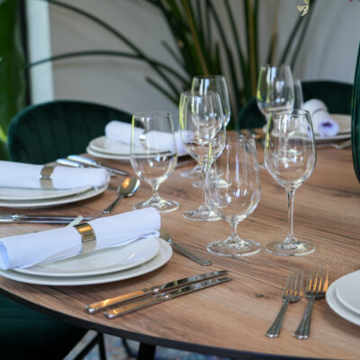 Oak Round Table I Carmen Cutlery I Riedel Glassware I RAK Crockery I Teddy Chair Emerald Green Velvet